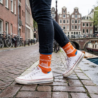 Orange Amsterdam Skyline socks worn beside an Amsterdam canal | Stand4 Socks