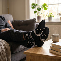 Black Bath Skyline socks worn while relaxing on a sofa at home | Stand4 Socks