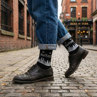 Black Belfast Skyline socks worn with leather shoes on a cobbled city street | Stand4 Socks