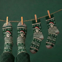 Green Christmas Theroux socks hanging from a clothesline against a dark green background | Stand4 Socks