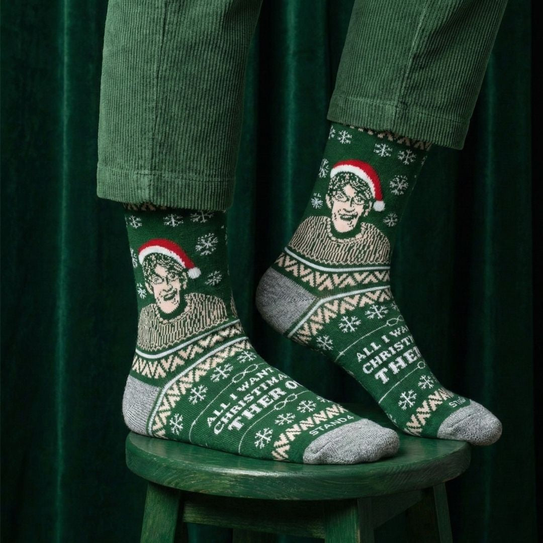 Green Christmas Theroux socks worn with green trousers while seated on a stool | Stand4 Socks