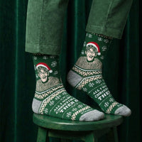 Green Christmas Theroux socks worn with green trousers while seated on a stool | Stand4 Socks