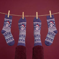 Purple Christmas Theroux socks hanging from a festive clothesline | Stand4 Socks