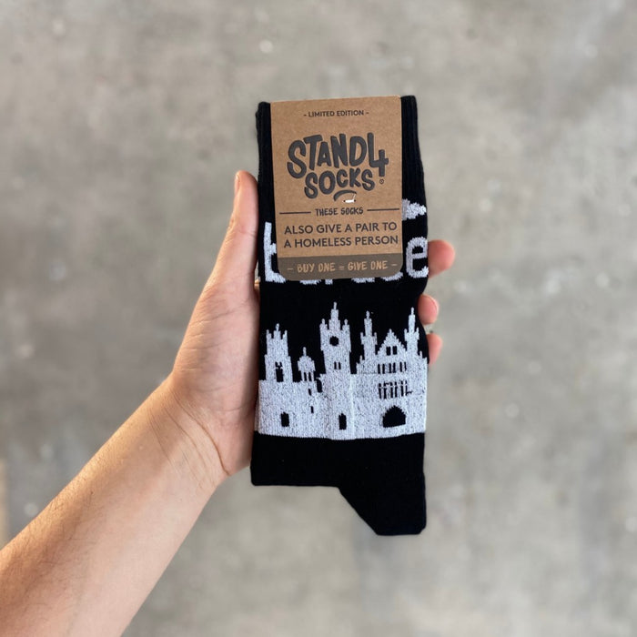 Black Aberdeen Skyline sock in packaging held against a grey background | Stand4 Socks buy one, give one to someone homeless