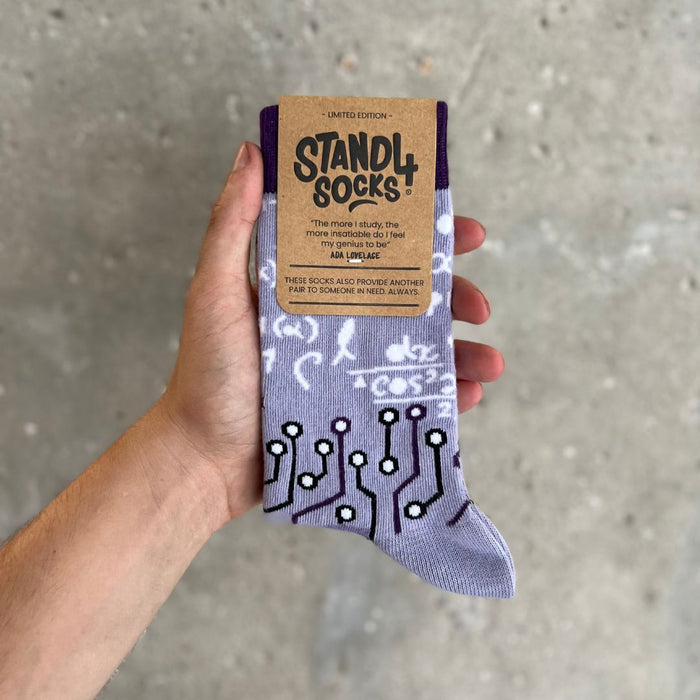 Ada Lovelace crew socks in gift packaging held against a grey background | Stand4 Socks buy one, give one to someone homeless