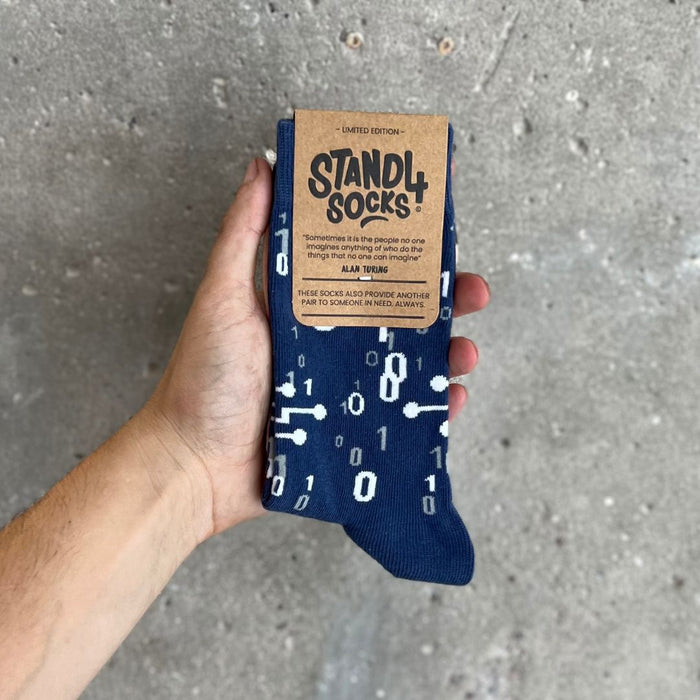 Alan Turing sock in packaging held against a grey background | Stand4 Socks buy one, give one to someone homeless