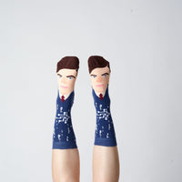 Navy Alan Turing portrait socks worn on raised feet against a grey background | Stand4 Socks