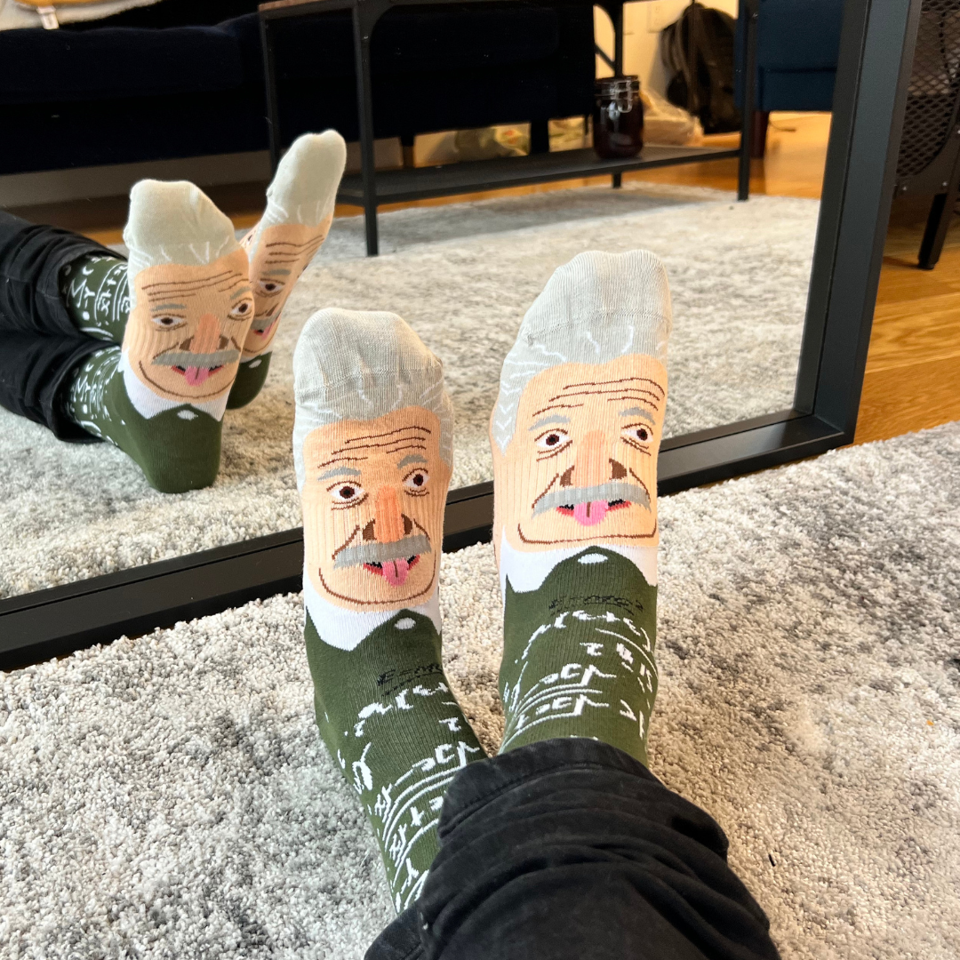 Albert Einstein portrait socks worn on both feet in front of a mirror | Stand4 Socks