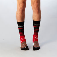 Red and black Be More Rashford socks worn by a standing model | Stand4 Socks