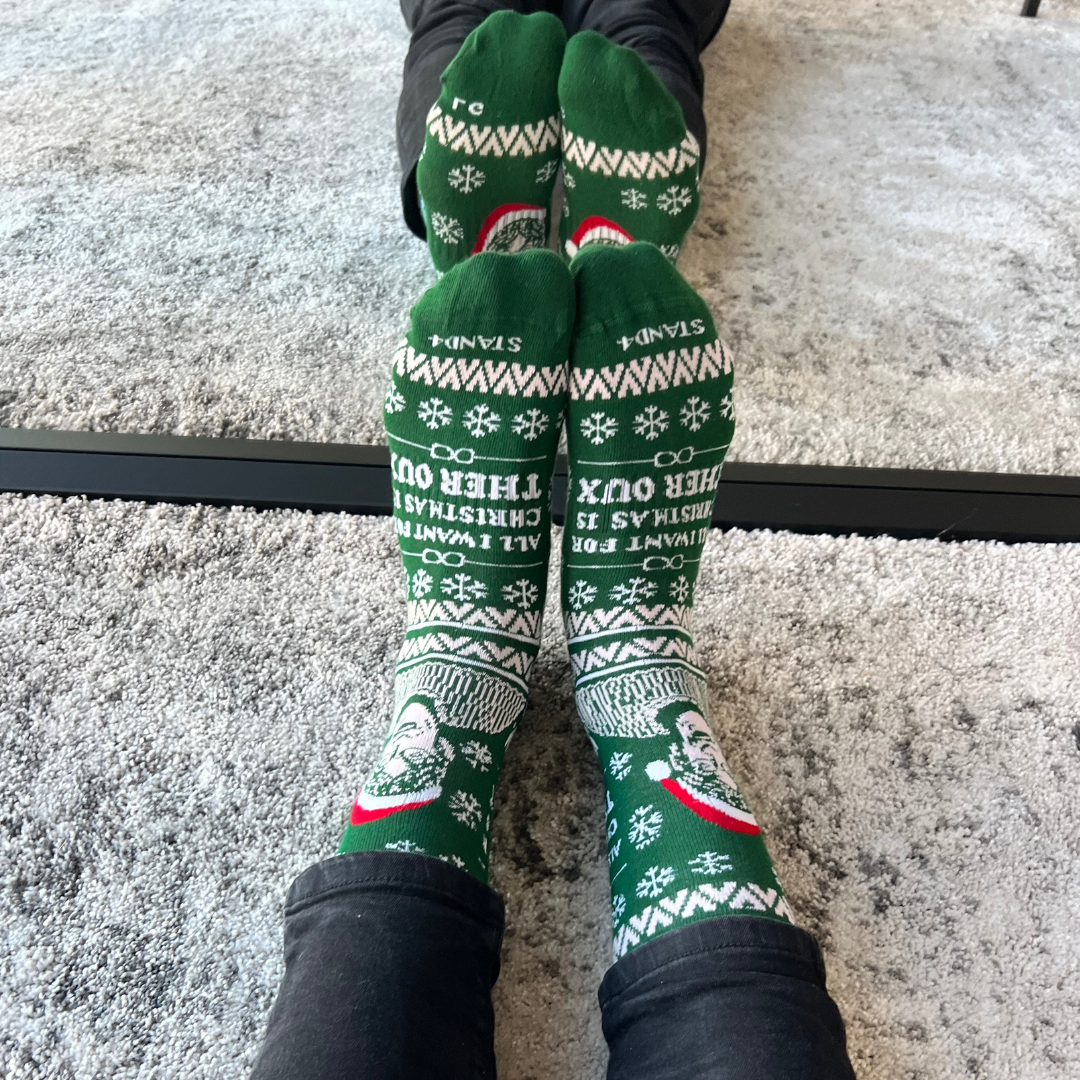 Green Christmas Theroux socks worn on both feet in front of a mirror | Stand4 Socks