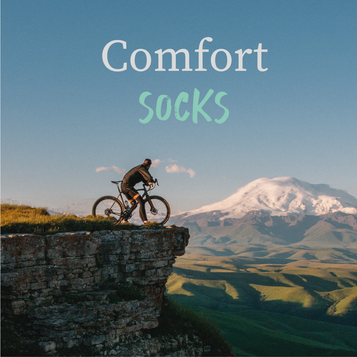 Cyclist riding through a mountain landscape promoting COOLMAX cycling socks | Stand4 Socks